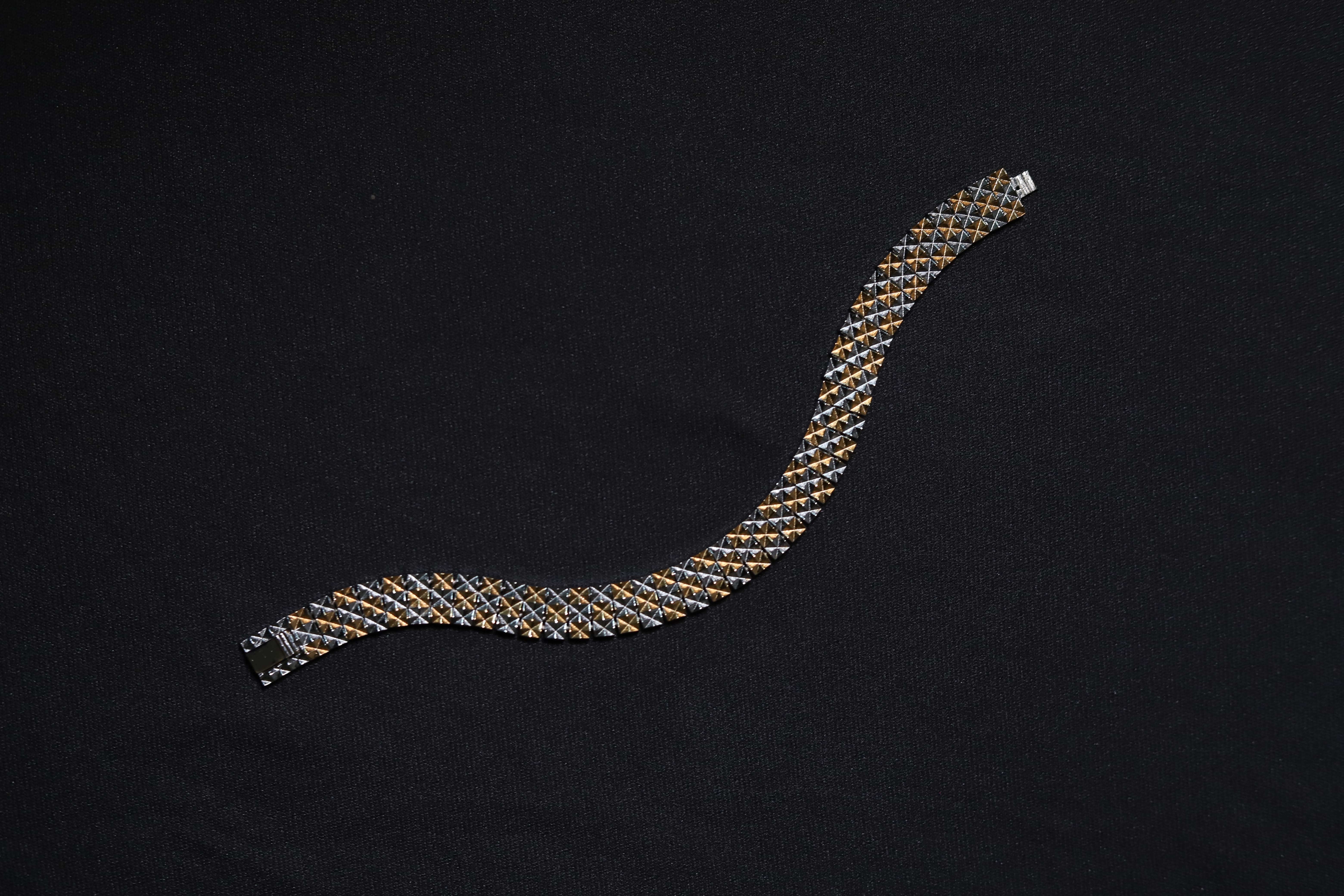 Close-up of pure silver dual-tone checkered men's bracelet on wrist